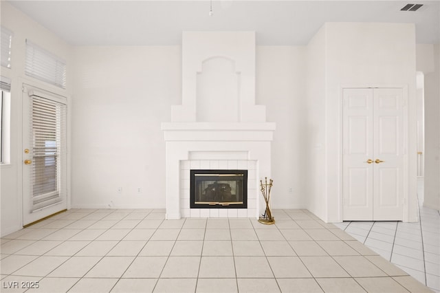 unfurnished living room featuring a fireplace and light tile patterned floors