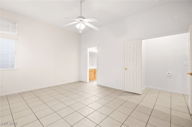 tiled spare room with ceiling fan