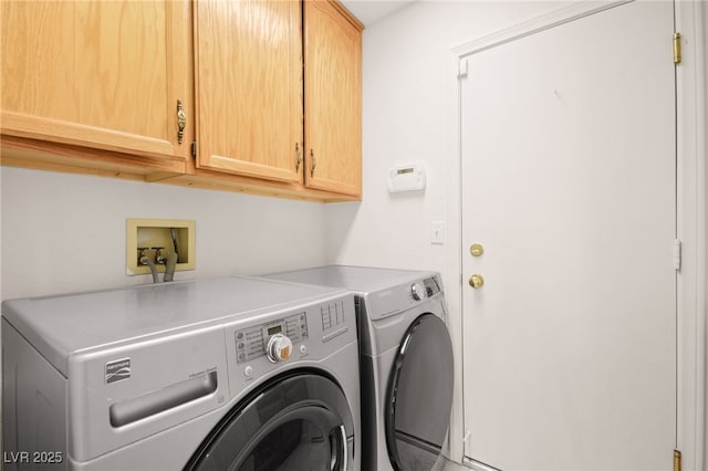 washroom with washing machine and dryer and cabinets