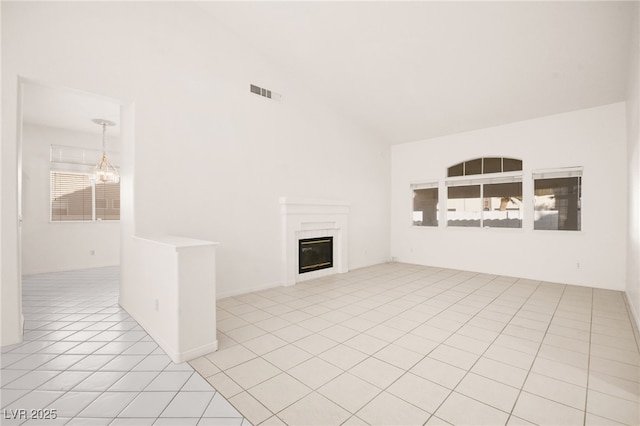 unfurnished living room featuring lofted ceiling, an inviting chandelier, and light tile patterned floors