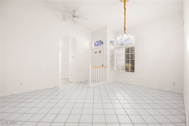 tiled spare room with ceiling fan with notable chandelier and high vaulted ceiling