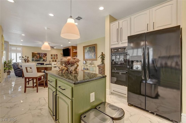 kitchen featuring green cabinets, decorative light fixtures, black appliances, a kitchen island, and white cabinetry