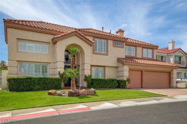 mediterranean / spanish house with a front lawn and a garage