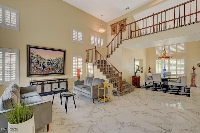 living room with a notable chandelier and a towering ceiling