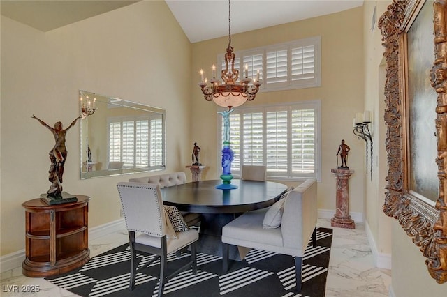 dining room featuring a towering ceiling and a notable chandelier