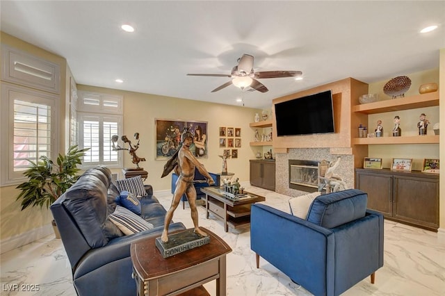 living room featuring a premium fireplace, ceiling fan, and built in features