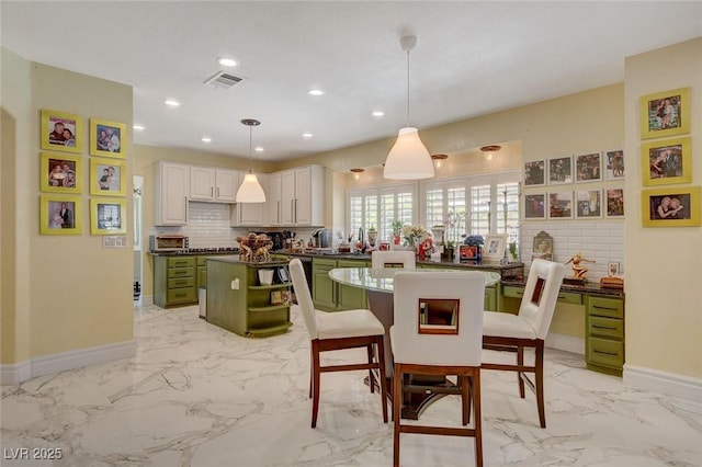 kitchen with decorative light fixtures, green cabinetry, decorative backsplash, and white cabinetry