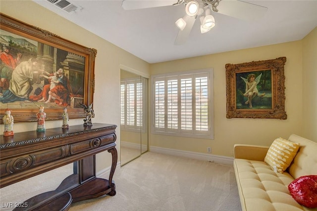 sitting room with ceiling fan and carpet flooring