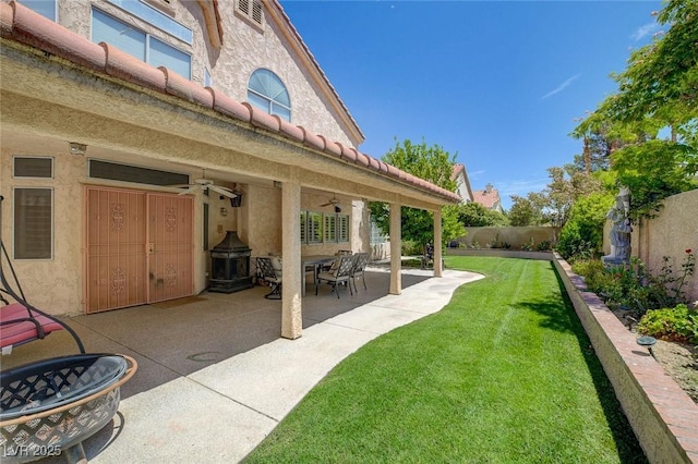 view of yard featuring a patio area and ceiling fan