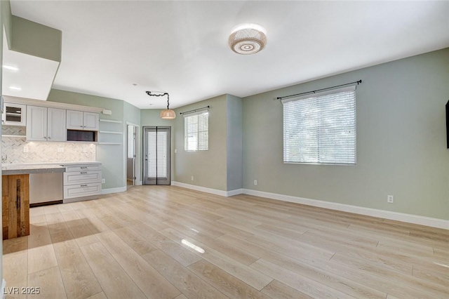 kitchen with light hardwood / wood-style flooring, hanging light fixtures, white cabinetry, and tasteful backsplash