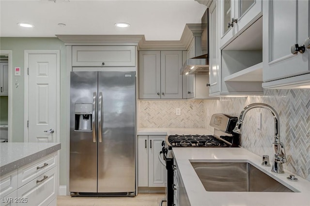 kitchen featuring stainless steel appliances, decorative backsplash, sink, and light stone countertops