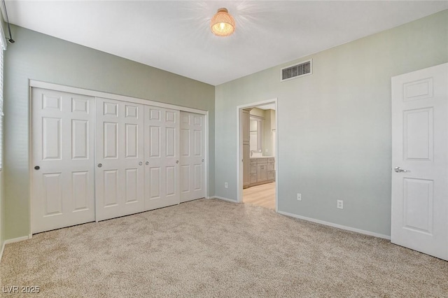 unfurnished bedroom featuring light colored carpet and a closet