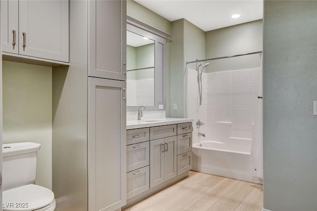 full bathroom with toilet, hardwood / wood-style flooring, bathtub / shower combination, and vanity