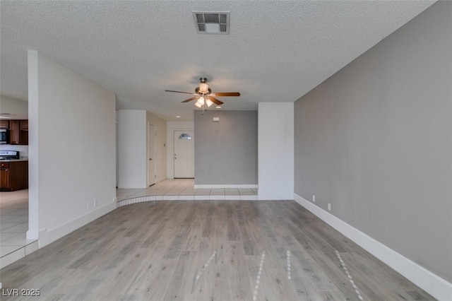 unfurnished living room with a textured ceiling, ceiling fan, and light wood-type flooring