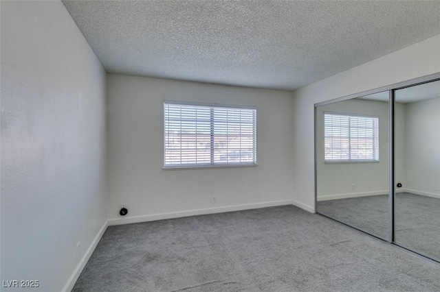 unfurnished bedroom featuring a closet, light carpet, and multiple windows