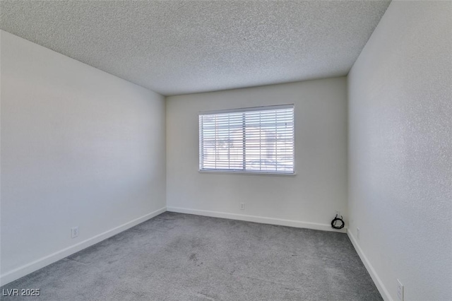 carpeted empty room featuring a textured ceiling