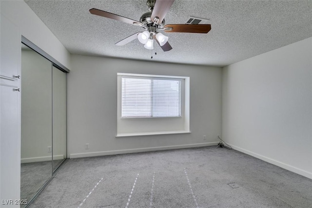 unfurnished bedroom featuring light carpet, a closet, and ceiling fan