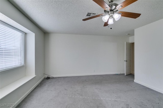 carpeted spare room featuring a textured ceiling and ceiling fan