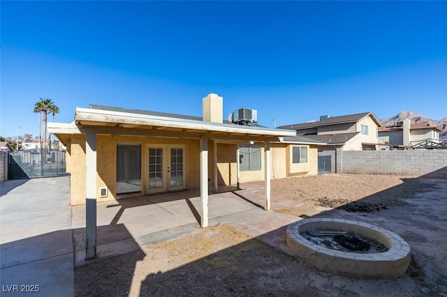 back of house featuring an outdoor fire pit, central AC, and a patio