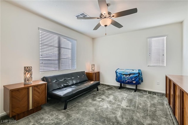 living area with ceiling fan and dark carpet