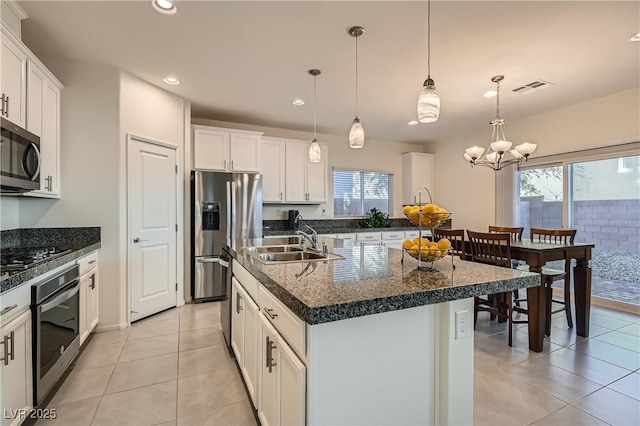 kitchen featuring a chandelier, decorative light fixtures, a center island with sink, appliances with stainless steel finishes, and sink