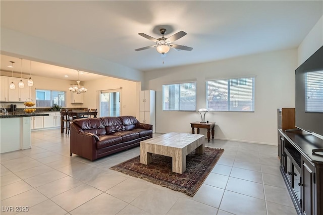 tiled living room featuring ceiling fan with notable chandelier