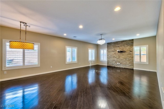 unfurnished living room with dark wood-type flooring and a chandelier