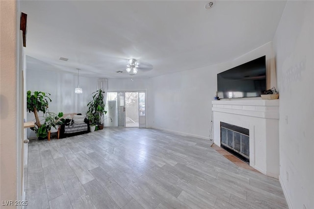 unfurnished living room featuring ceiling fan and light wood-type flooring