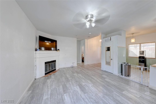 unfurnished living room featuring light wood-type flooring and ceiling fan