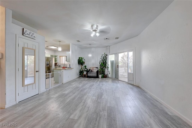 unfurnished living room with ceiling fan and light hardwood / wood-style floors