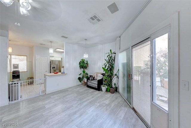 interior space with light wood-type flooring and ceiling fan