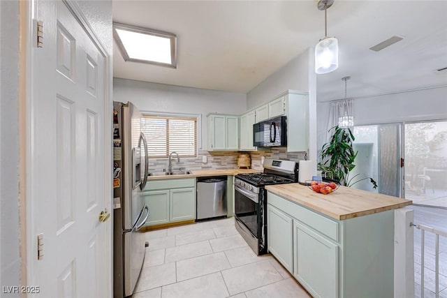 kitchen with pendant lighting, tasteful backsplash, wooden counters, appliances with stainless steel finishes, and sink