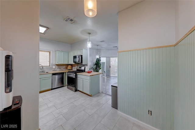 kitchen featuring a healthy amount of sunlight, stainless steel appliances, decorative light fixtures, and backsplash