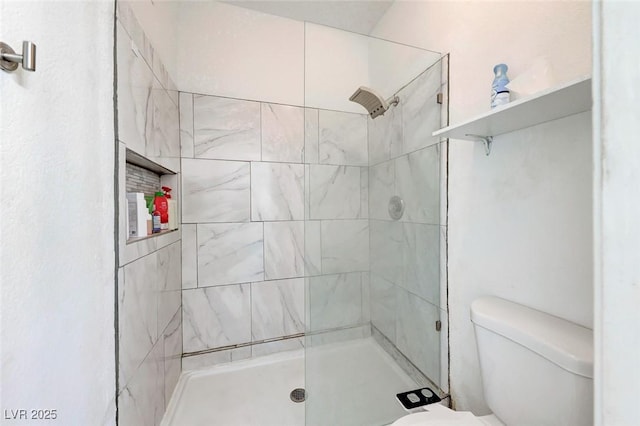 bathroom with a shower with door and toilet