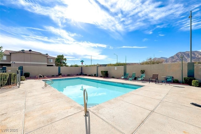 view of swimming pool featuring a patio and a mountain view