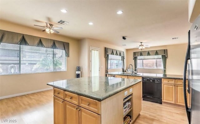 kitchen featuring a kitchen island, plenty of natural light, black appliances, and sink