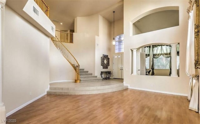 entryway featuring a towering ceiling and hardwood / wood-style flooring