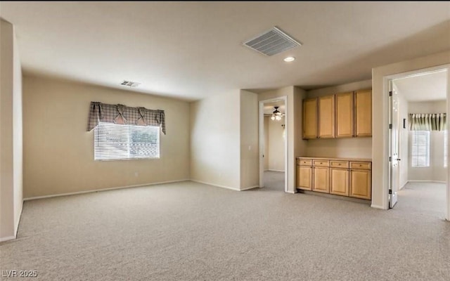 unfurnished living room with light carpet and plenty of natural light