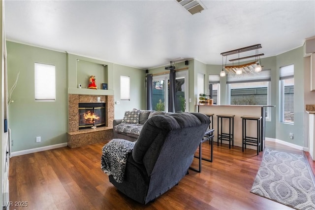 living room with dark hardwood / wood-style flooring, a wealth of natural light, and a fireplace