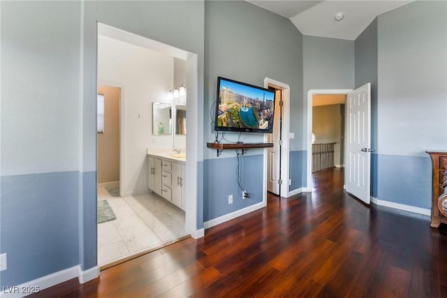 bathroom with hardwood / wood-style flooring, vaulted ceiling, and vanity