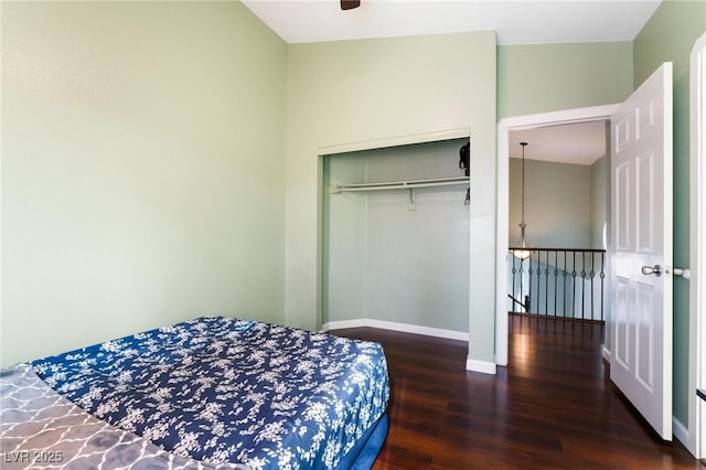 bedroom featuring ceiling fan, dark hardwood / wood-style flooring, and a closet