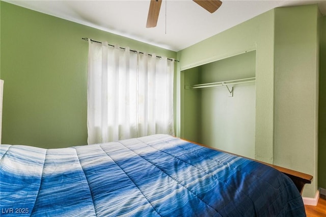 bedroom with wood-type flooring, ceiling fan, and a closet