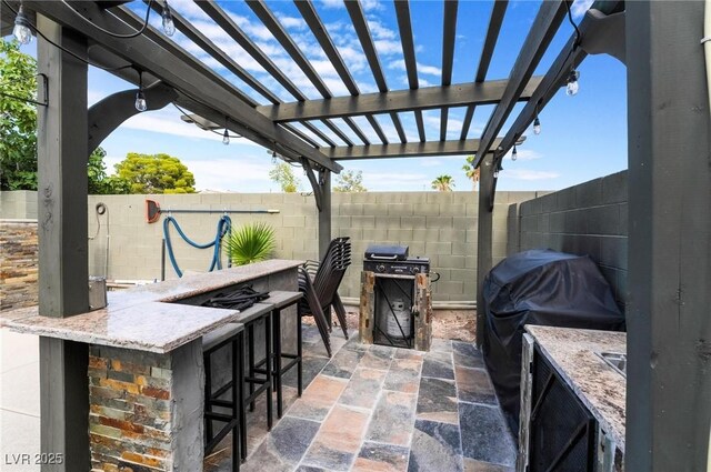 view of patio / terrace featuring a pergola, an outdoor bar, and grilling area