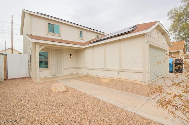 view of front facade with a garage and solar panels