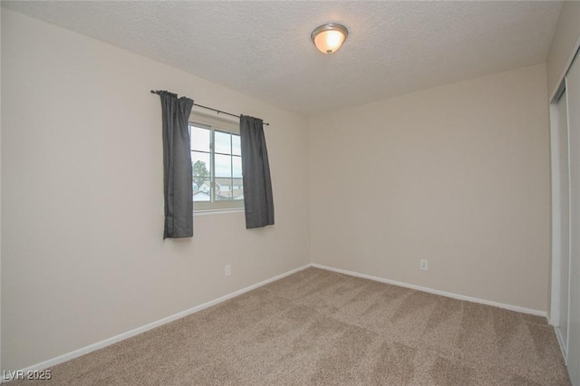 carpeted empty room featuring a textured ceiling