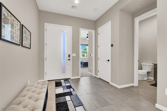 foyer with ceiling fan and light tile patterned floors