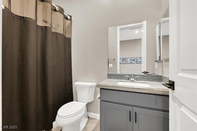 bathroom featuring toilet, vanity, and curtained shower