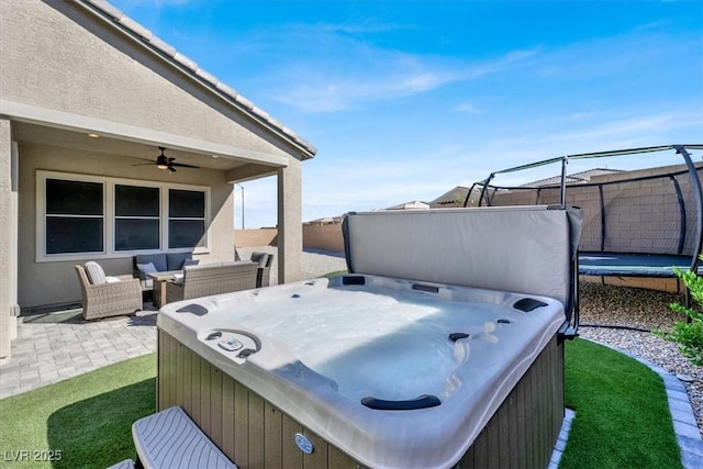 view of patio / terrace with ceiling fan, a hot tub, outdoor lounge area, and a trampoline