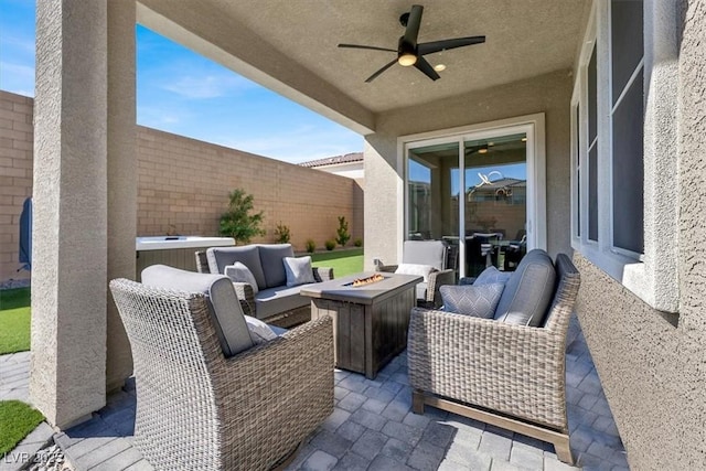 view of patio with ceiling fan and an outdoor living space with a fire pit