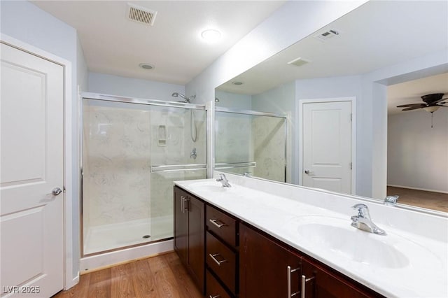 bathroom featuring vanity, wood-type flooring, a shower with door, and ceiling fan